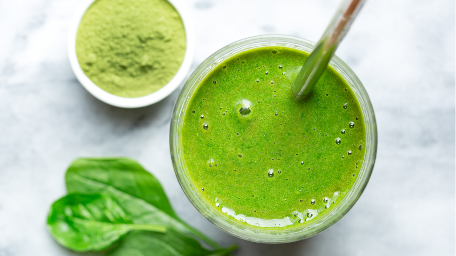 Smoothie verde detox con superalimentos saludables como espinaca y jengibre.